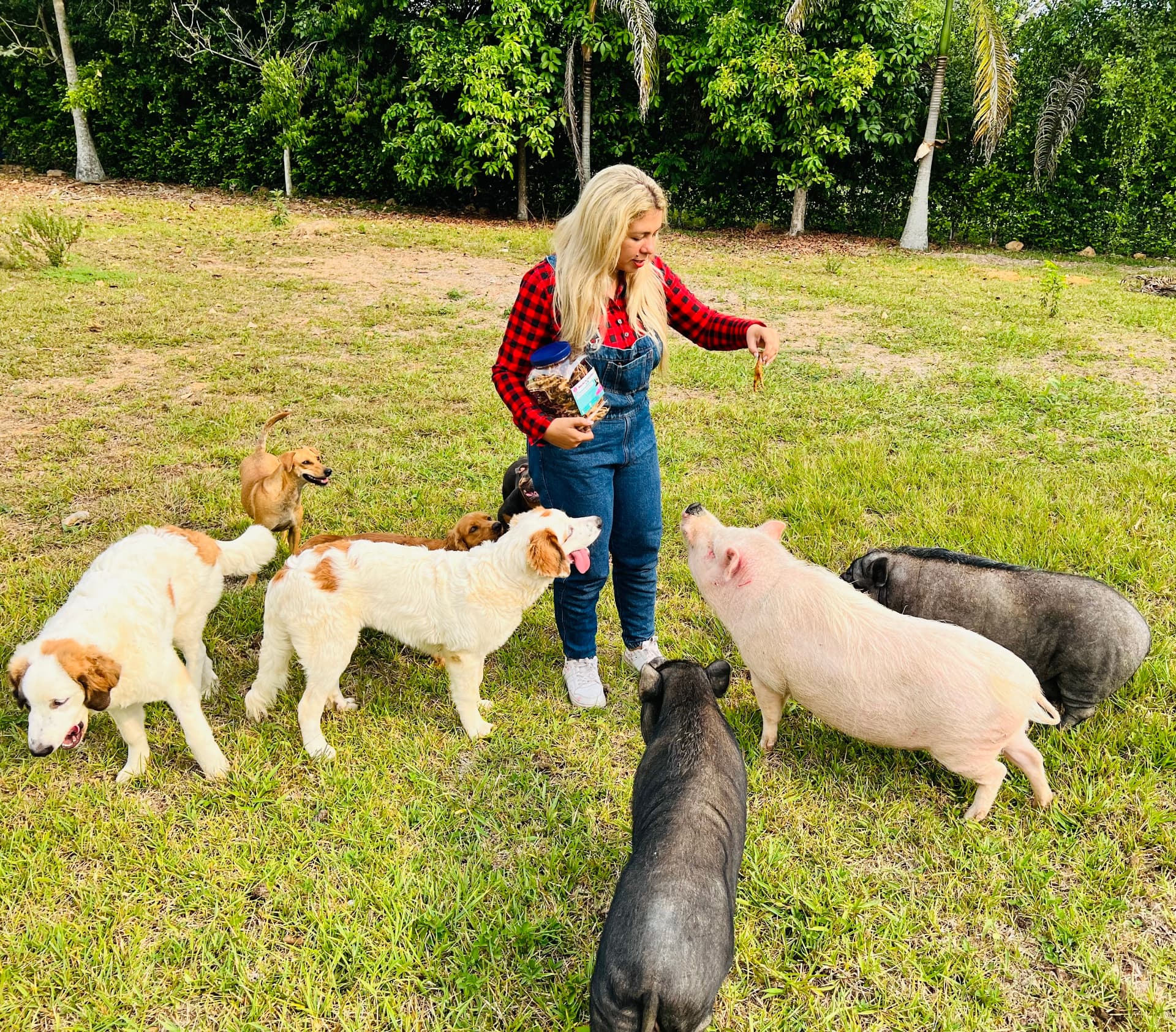 Ibeth con los perros y cerditos rescatados en El Ranchito de Ibeth